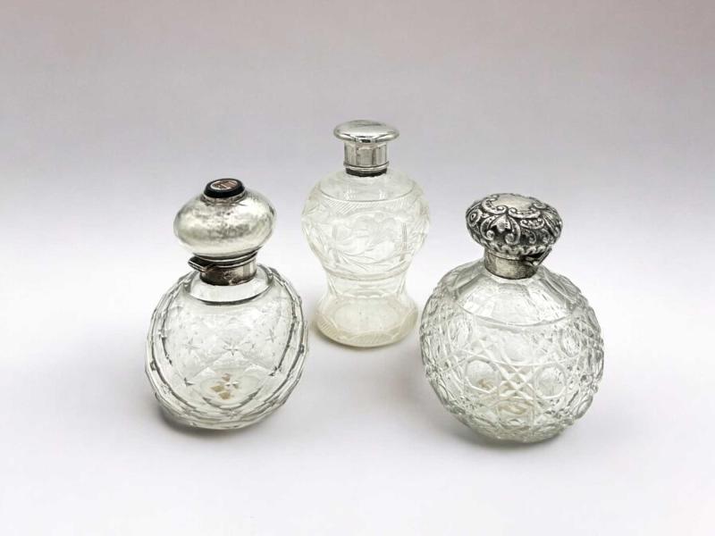 Tre bottiglie da profumo in cristallo intagliato con tappi in argento, una con micromosaico raffigurante il Pantheon Tre bottiglie da profumo in cristallo intagliato con tappi in argento, una con micromosaico raffigurante il Pantheon