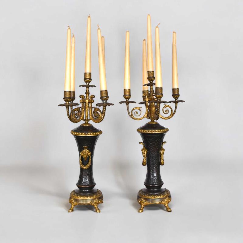 Coppia di candelabri in metallo dorato ed in parte brunito Coppia di candelabri in metallo dorato ed in parte brunito